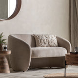 Cream armchair with a textured pillow in a modern living room setting.